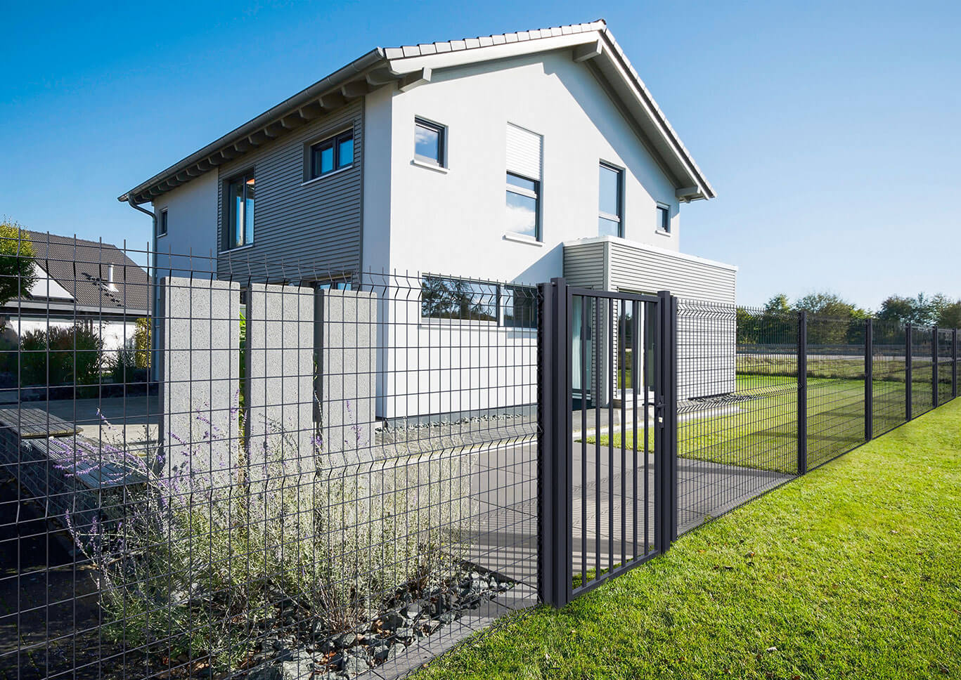 Maison neuve clôturée par des panneaux rigides et un portillon Clotex